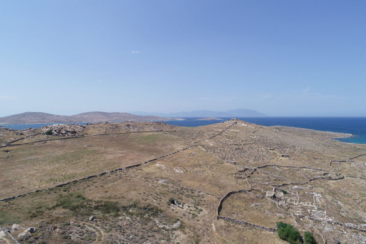 The Hellenistic necropolis of Delos on Rheneia, the pyramid shaped hill of Chomasovouni where the site of the Artemision on the island is likely to be. To the left, an ancient farmhouse next to a modern one. In the background, the northern part of Rheneia and Tinos on the horizon. (photo: MOCAS)