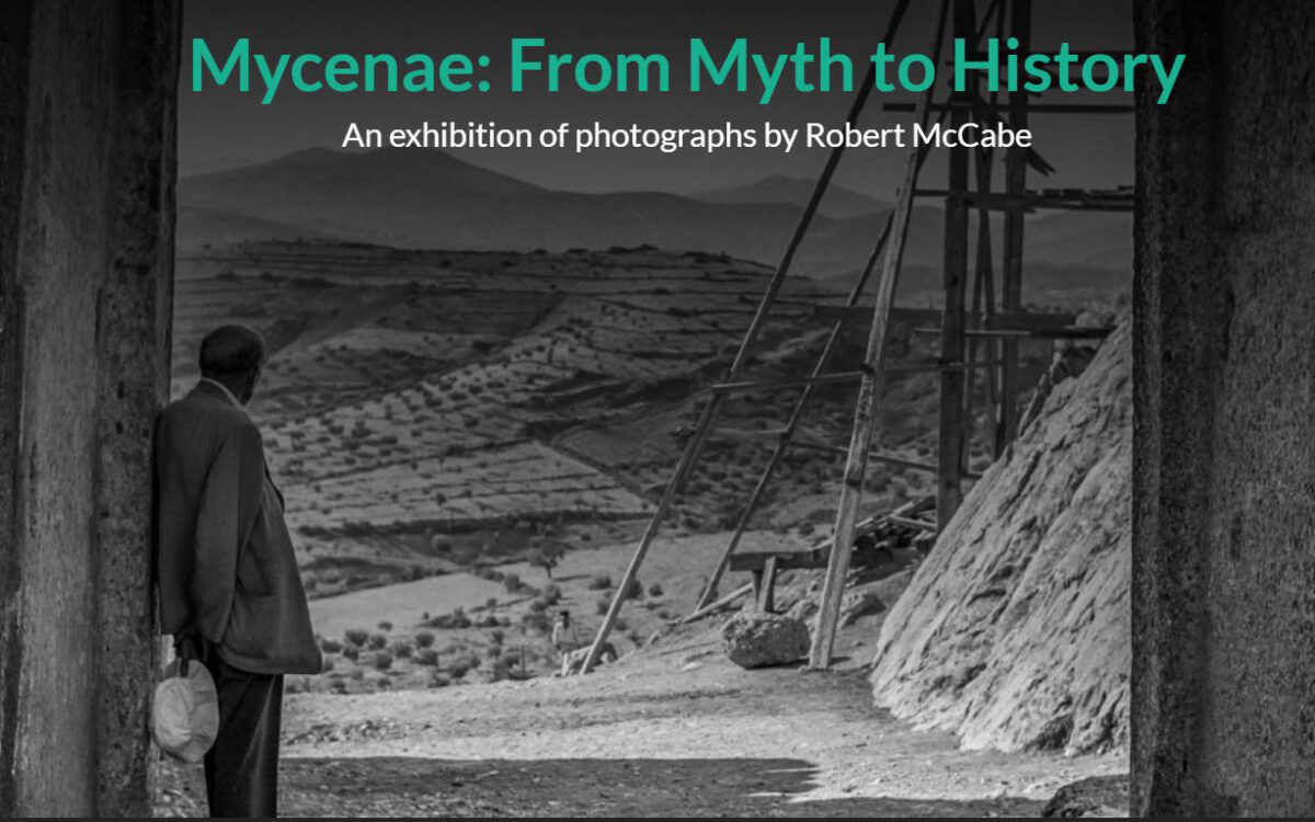 Poster of the exhibition. Alan Wace looking out from the Lion Gate toward the roads leading north past some of the richest cemeteries of Mycenae. Copyright: Robert McCabe.  
