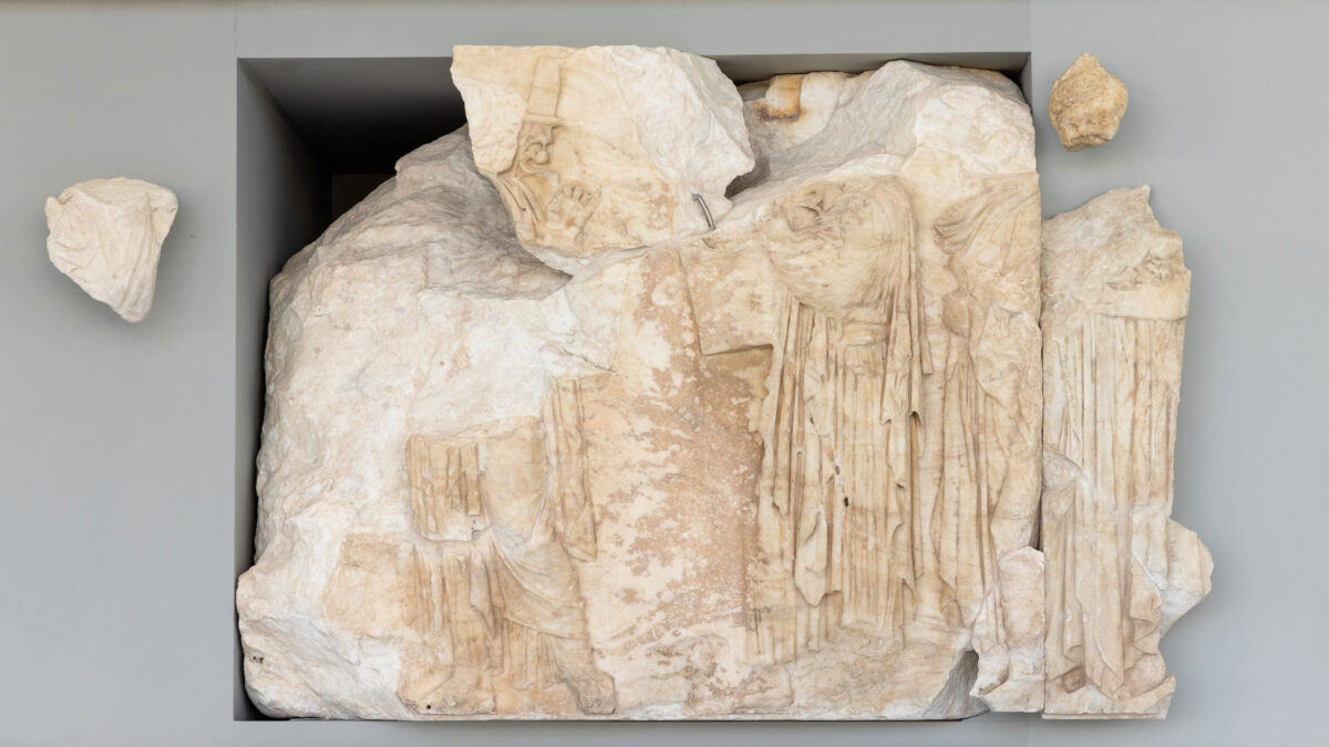 The second head is attributed to the first from the left figure of a thallophoros (branch-bearer) of the Panathenaic procession, who is depicted on block IX of the north frieze.