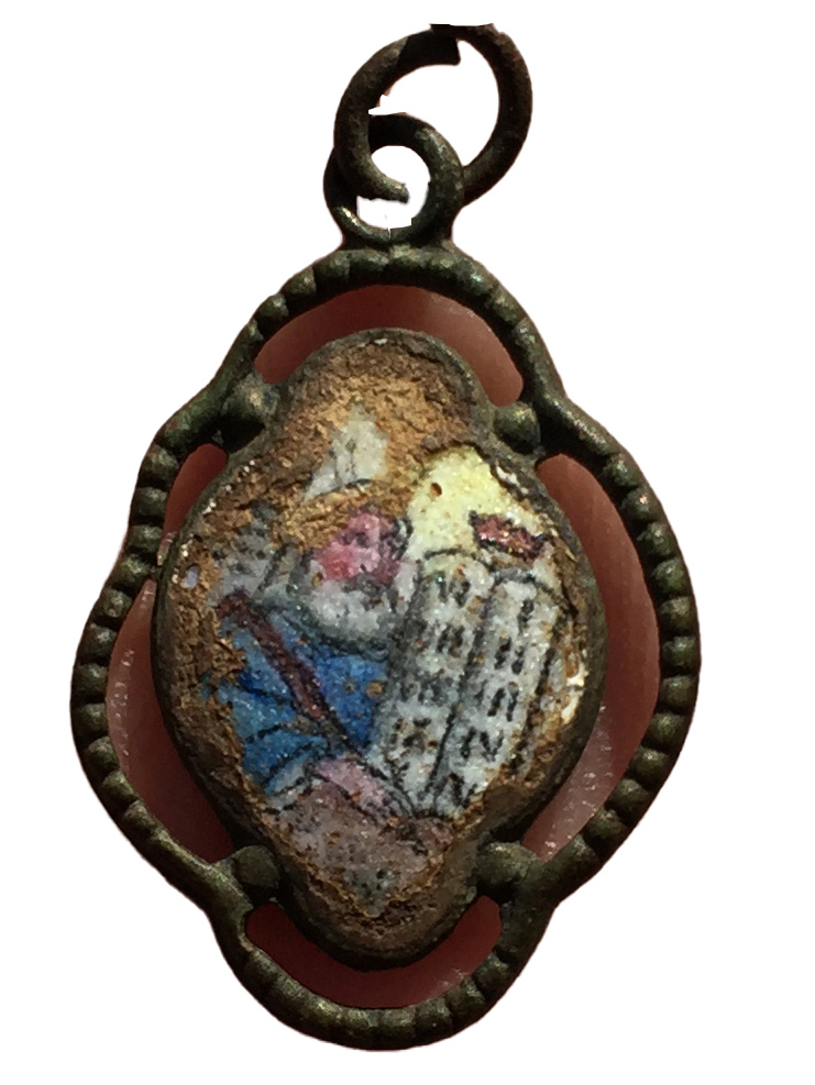 Depiction of Moses and the tablets of the Law on the pendant found in the area where victims were undressed before being led to the gas chambers in Camp II at Sobibor. Photo: Wojciech Mazurek