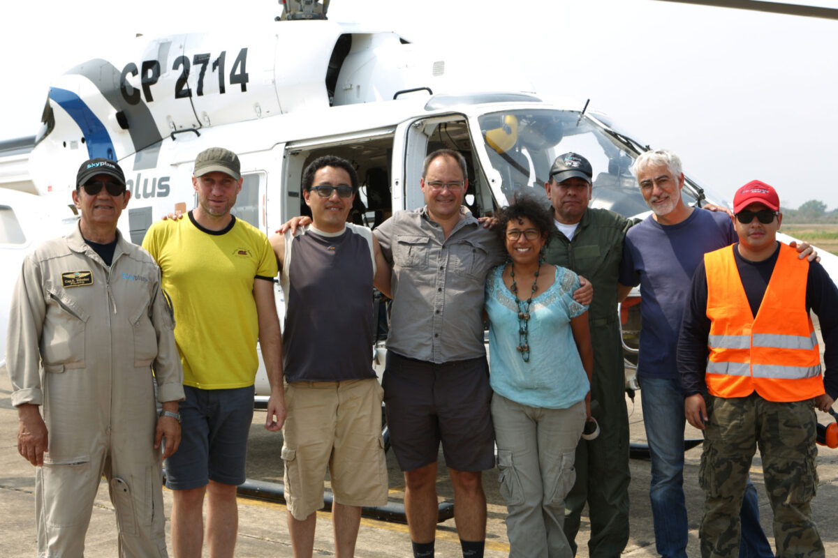 The authors of the paper together with the crew in front of the helicopter flying the lidar scanner over the area.