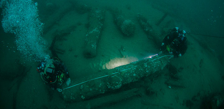 Julian and Lincoln Barnwell measure one of the Gloucester's cannons. © Norfolk Historic Shipwrecks
