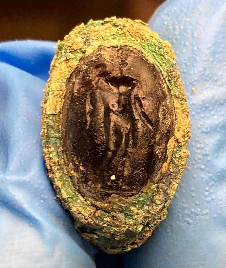 A bronze ring that was recovered inside one of the burial urns. The ring depicts Hercules wearing the skin of a lion and can be dated to the early 2nd century B.C.E. Image credit : University of Buffalo