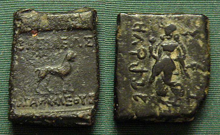 Indian coinage of Agathocles, with Buddhist lion and dancing woman holding lotus, possible Indian goddess Lakshmi, a goddess of abundance and fortune for Buddhists. Coin of Agathokles, king of Bactria (ca. 200–145 BC). British Museum. Personal photograph 2006. The coin shows inscriptions in Greek. Upper left: ΒΑΣΙΛΕΩΣ. Upper down: ΑΓΑΘΟΚΛΕΟΥΣ. The coin also shows a Buddhist lion and Lakshmi. Image: Wikimedia Commons