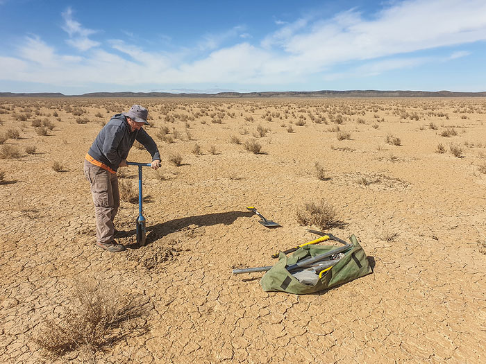 Andrew Carr collecting sediment samples dating to the Last Glacial Maximum from the dry lakebed at Swartkolkvloer. Credit: Brian Chase
