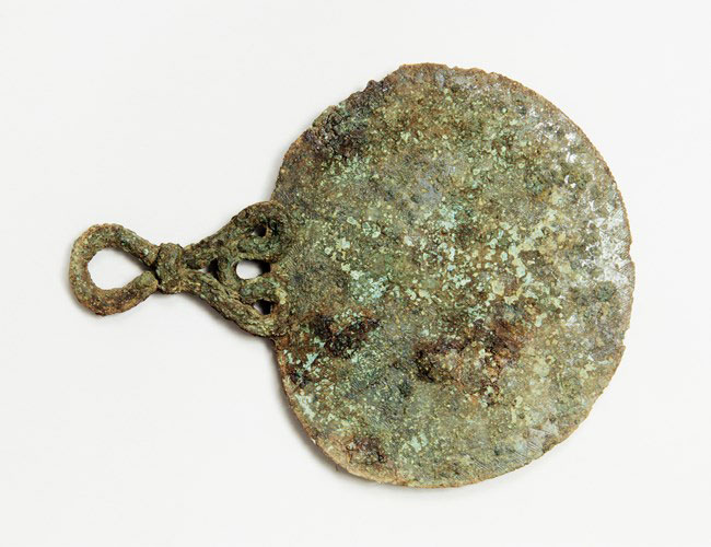 The bronze mirror found in a 2,000-year-old Iron Age burial on Bryher, the Isles of Scilly, just off the coast of Cornwall. © Historic England Archive. PLB K000687.