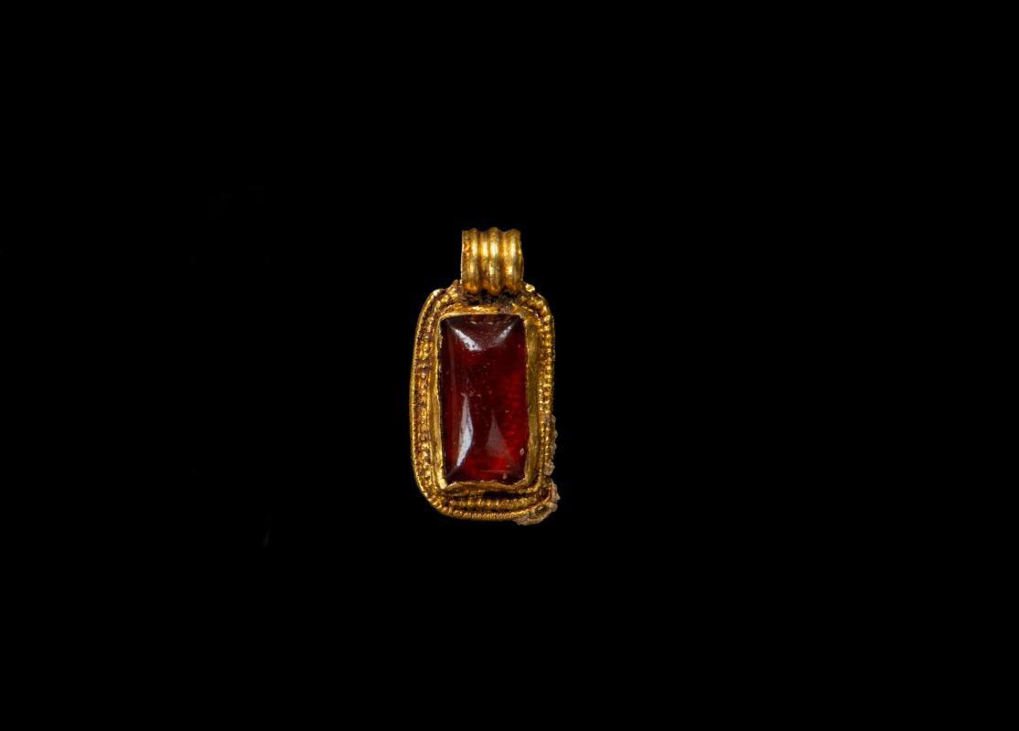 Anglo-Saxon gold pendant with garnet centre. © Wessex Archaeology.