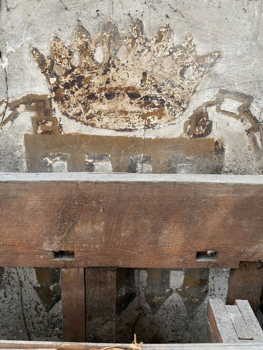 The crowned portcullis partially obscured by a joist. Photo: Tobit Curteis Associates LLP