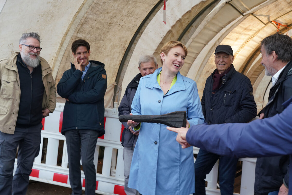 Fig. 5. Ms Andrea Lindlohr MdL, Staatssekretärin at the Baden-Württemberg Ministry for Regional Development and Housing, with the club-like wooden artefact left behind by the Celtic builders. Credit: LAD / Andreas Dubslaff
