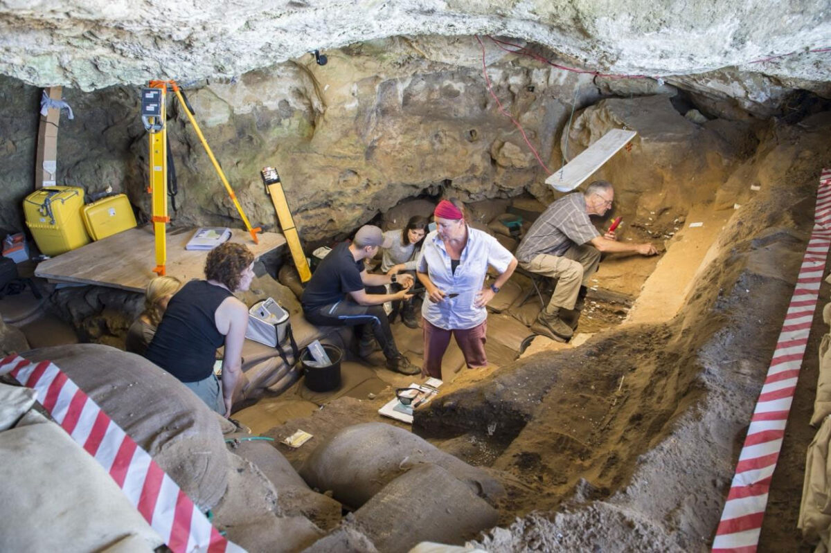 Inside Blombos Cave. Karen van Niekerk stands in the center, while Christopher Henshilwood is excavating on the left. Photo: SapienCE, UiB