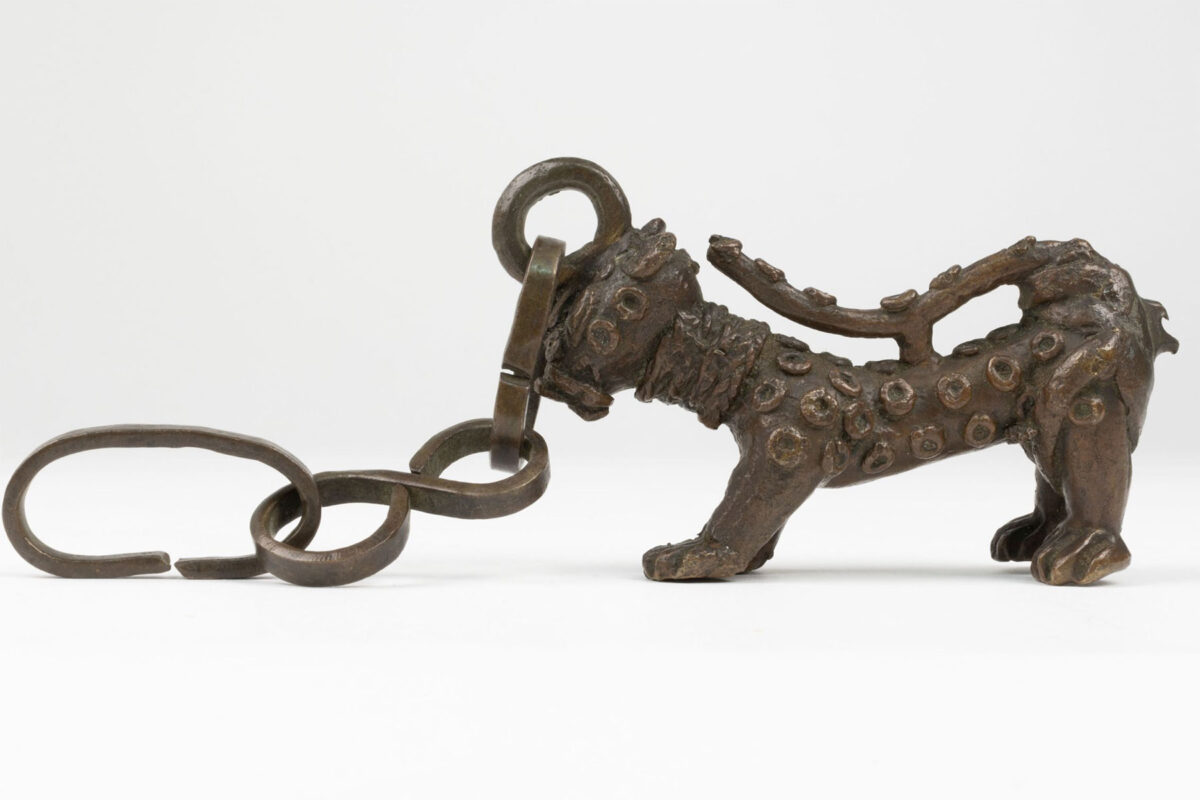 Brass leopard with raised spots, attached by the head to a chain. (MAA ID No. 1934.16)